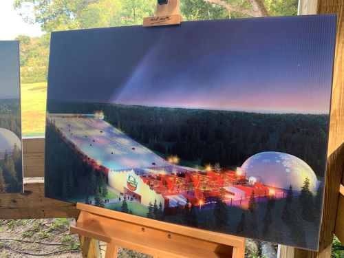 Concept art of a large indoor facility surrounded by trees, featuring a snowy slope and a dome structure.