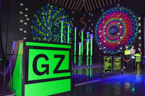 A vibrant indoor space with neon decorations, featuring a large "GZ" sign and colorful patterns on the walls.