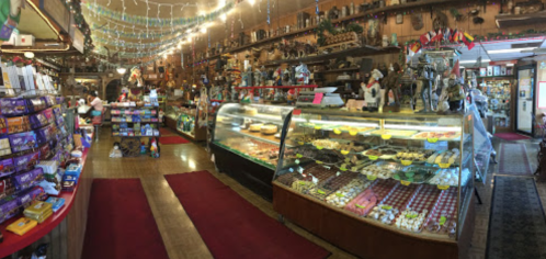 A cozy shop filled with colorful candies, baked goods, and festive decorations, showcasing a warm, inviting atmosphere.