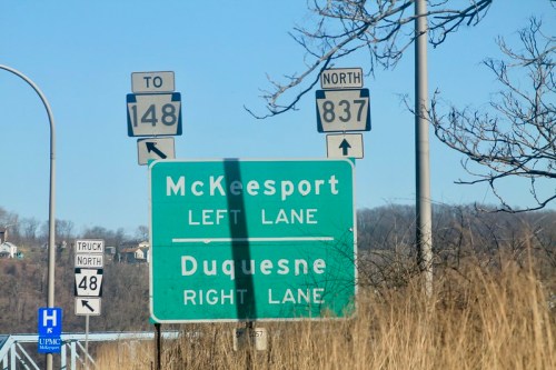 Road sign indicating directions to McKeesport (left lane) and Duquesne (right lane), with route numbers 148 and 837.