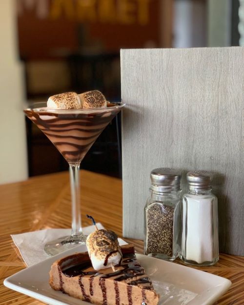 A chocolate dessert with a martini glass of layered chocolate and marshmallows, alongside salt and pepper shakers.