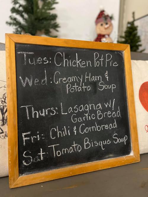 Chalkboard menu listing daily specials: Chicken Pot Pie, Creamy Ham & Potato Soup, Lasagna, Chili, and Tomato Bisque Soup.