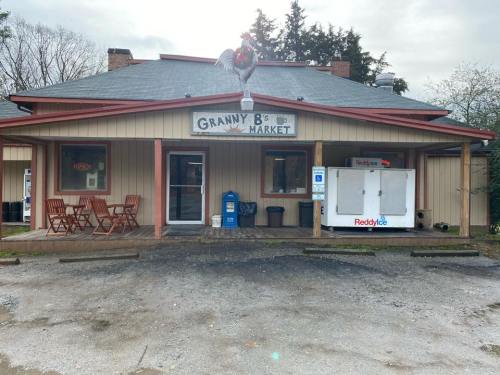 A small market with a sign reading "Granny B's Market," featuring outdoor seating and an ice machine outside.