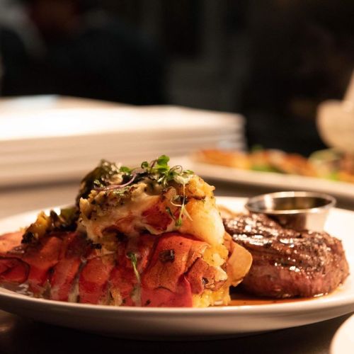 A plate featuring a grilled steak alongside a baked potato topped with cheese and herbs.