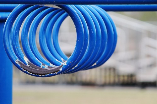 Close-up of blue playground rings, showing wear and tear, with a blurred background of playground equipment.