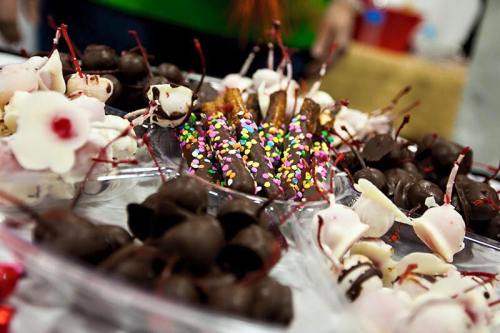 A colorful assortment of chocolate-covered treats, including cherries and sprinkles, arranged on a platter.