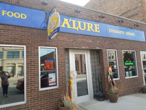 Exterior of a restaurant named "A'lure," featuring a sign and decorative elements like a scarecrow.