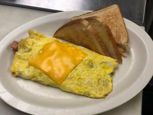 A plate with a cheesy omelette and three slices of toasted bread.