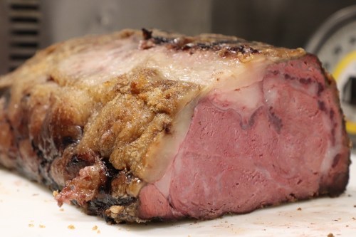 A close-up of a perfectly cooked roast beef with a crispy exterior and pink, juicy interior.