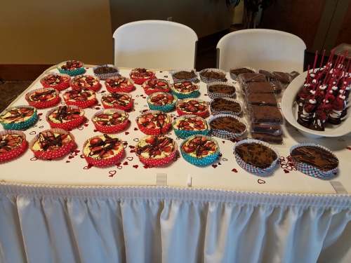 A table covered with colorful decorated cupcakes, brownies, and chocolate-covered treats, all arranged neatly.