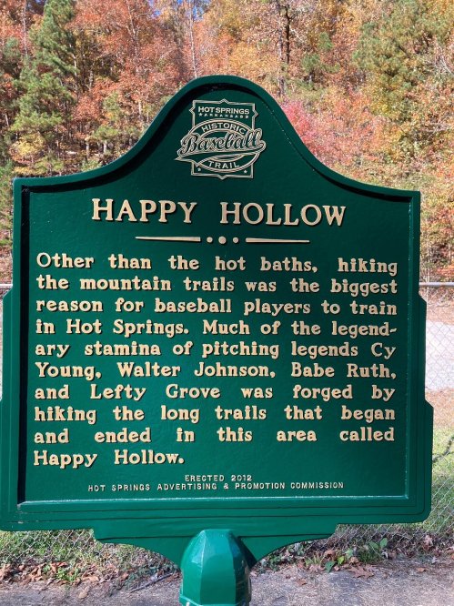 A green historical marker about Happy Hollow, highlighting its significance for baseball training in Hot Springs.