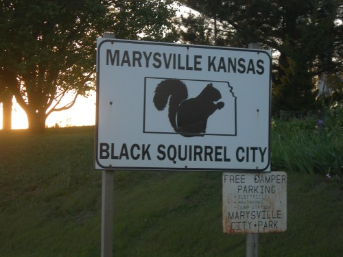 Sign for Marysville, Kansas, featuring a silhouette of a squirrel, labeled "Black Squirrel City" with parking information below.
