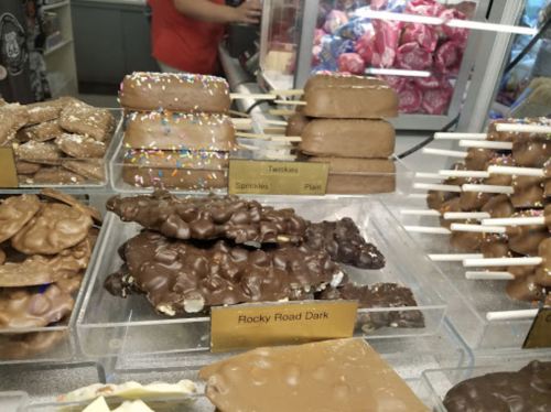A display of various chocolate treats, including Rocky Road Dark, Twinkies, and chocolate-covered snacks with sprinkles.
