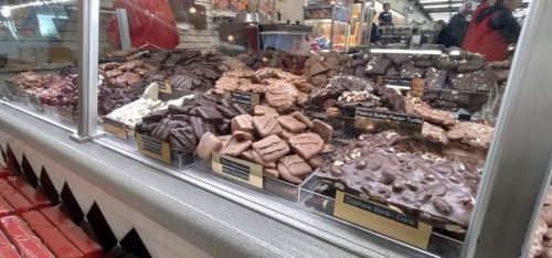 A display case filled with various types of chocolates and confections, including fudge and peanut butter treats.