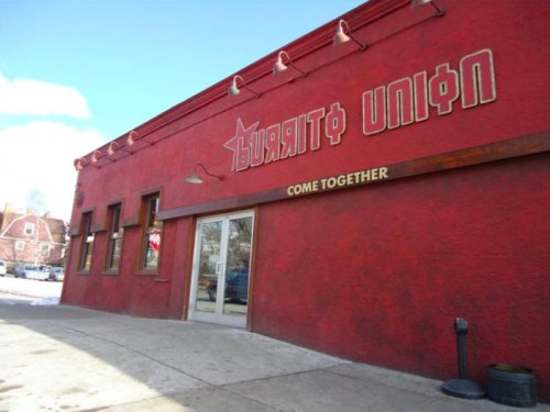 Exterior of a red building with the words "Burrito Union" and "Come Together" on a wooden sign above the entrance.
