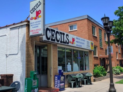 A storefront with the sign "Cecils," featuring a deli, restaurant, and bakery, surrounded by outdoor seating.