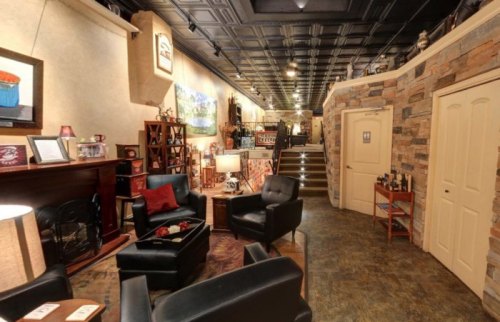Cozy interior of a shop featuring black leather chairs, decorative items, and a warm, inviting atmosphere.