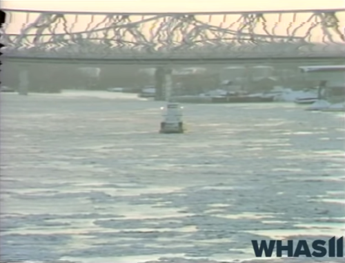 A river scene with ice floes and a bridge in the background, capturing a chilly winter atmosphere.
