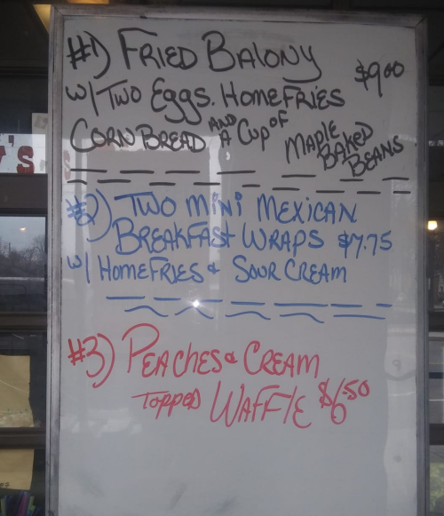Menu board featuring three breakfast items: Fried Baloney, Mini Mexican Wraps, and Peaches & Cream Waffle with prices.