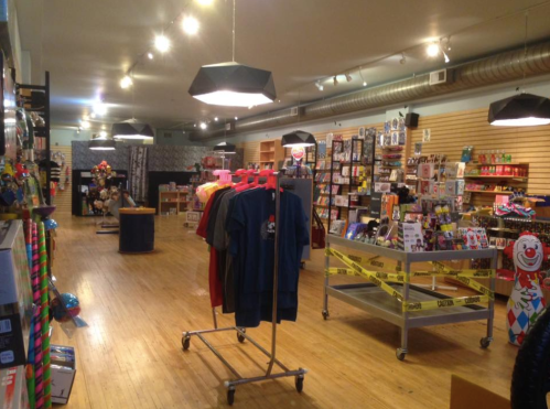 A colorful retail store interior with shelves of merchandise, clothing racks, and playful decor.