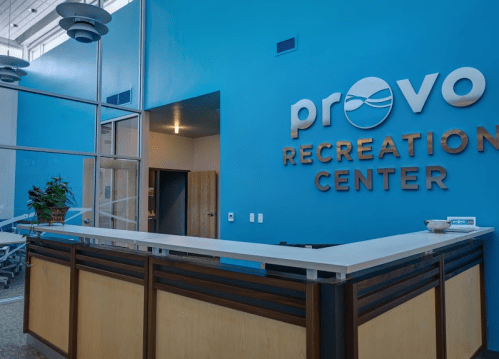 Reception area of the Provo Recreation Center, featuring a blue wall and modern design elements.
