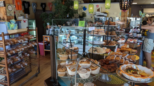 A cozy bakery display featuring various baked goods, including cookies, muffins, and pastries, with a warm atmosphere.