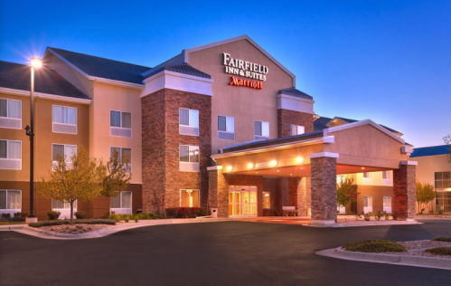 Exterior view of the Fairfield Inn & Suites by Marriott, featuring a welcoming entrance and evening lighting.