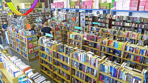 Aerial view of a bustling bookstore filled with shelves of books and customers browsing.