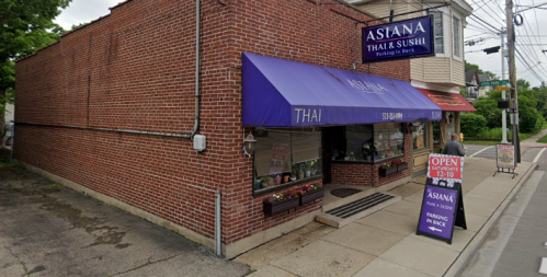 Exterior of Asiana Thai & Sushi restaurant, featuring a brick facade, blue awning, and an open sign.