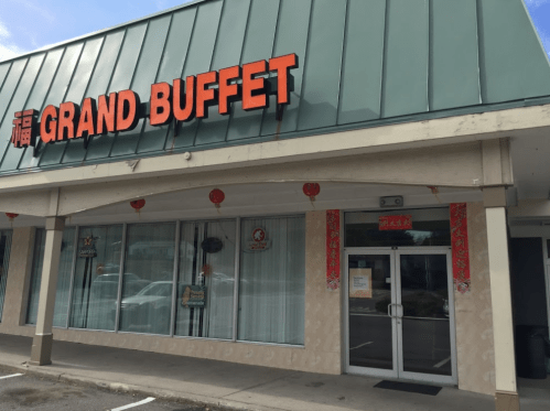 Exterior of a restaurant named "Grand Buffet," featuring a green awning and decorative lanterns.