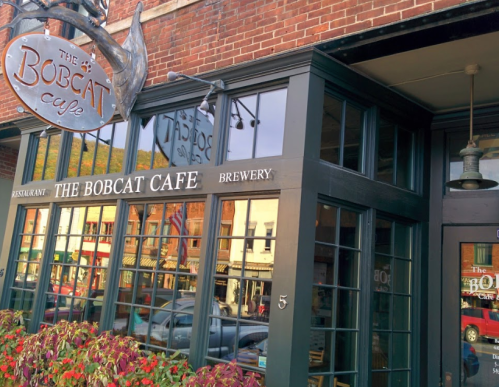 Exterior of The Bobcat Cafe and Brewery, featuring large windows and a sign above the entrance.