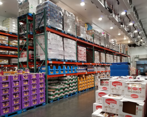 A warehouse interior with tall shelves stacked with various food products and boxes, creating an organized storage space.