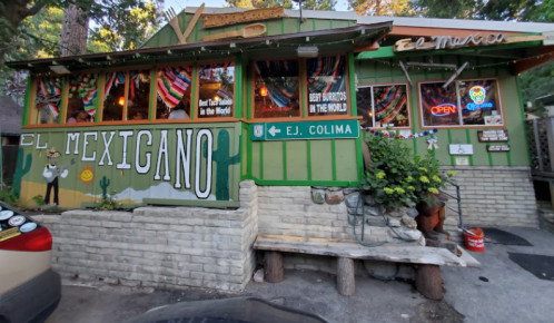 Colorful exterior of a Mexican restaurant with vibrant decorations, signs, and plants outside.