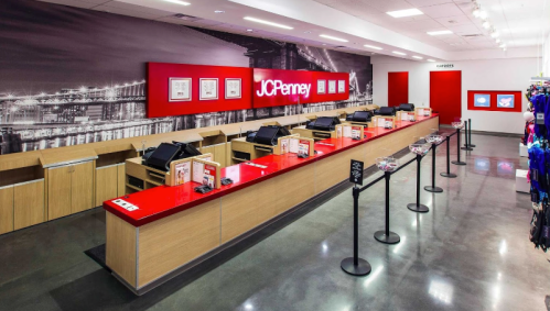 Interior of a JCPenney store featuring a modern checkout area with red accents and multiple registers.