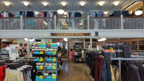 Interior of Kemmerer Store, featuring clothing displays, shelves, and a second-floor balcony with more merchandise.