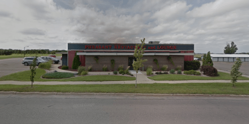 Exterior view of Pheasant Restaurant and Lounge, featuring a brick facade and landscaped surroundings on a cloudy day.