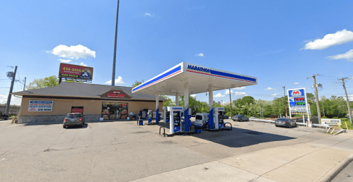 A Marathon gas station with fuel pumps, a convenience store, and clear blue skies in the background.