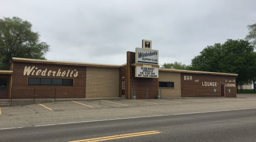 Exterior of Wiederholt's Supper Club, featuring a bar and lounge sign, with a classic mid-century design.