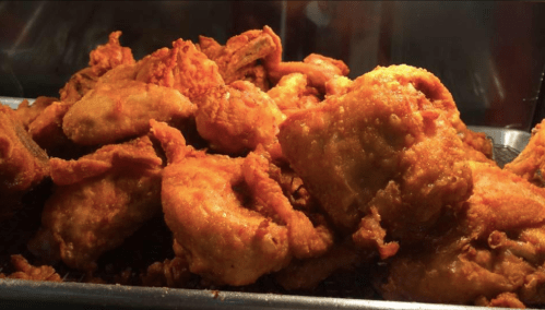 A close-up of a pile of crispy, golden-brown fried chicken pieces.