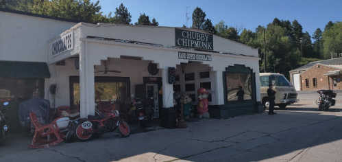 A vintage shop named "Chubby Chipmunk" with motorcycles outside and cartoon chipmunk figures on display.