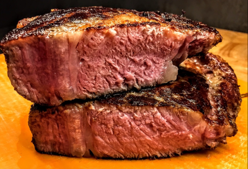 Close-up of two thick, juicy steak slices with a perfectly seared crust and pink, tender interior.