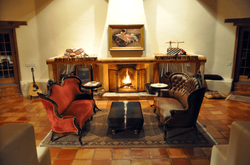 Cozy living room with a fireplace, two elegant sofas, a coffee table, and warm lighting.