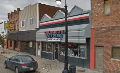 Exterior of Colombo's Coney Island restaurant, featuring a colorful sign and a parked car on a city street.