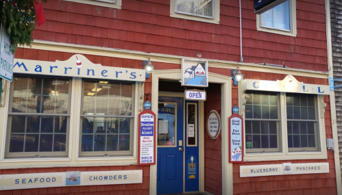 Exterior of Marriner's Grill, a red building with signs for seafood, chowders, and pancakes, marked "OPEN."