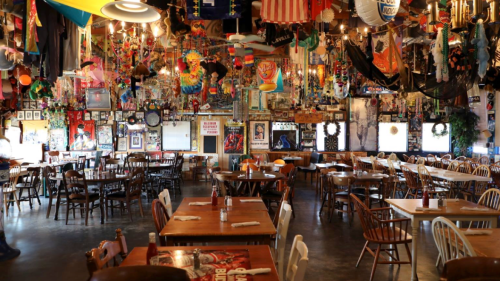 A vibrant restaurant interior filled with colorful decorations, tables, and chairs, creating a lively atmosphere.