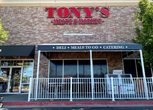 Exterior of Tony's Meats & Market featuring a sign and a covered entrance with options for deli, meals to go, and catering.