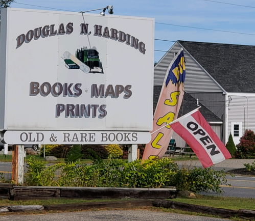 Sign for Douglas N. Harding featuring "Books, Maps, Prints" and flags indicating "Open" and "Sale."