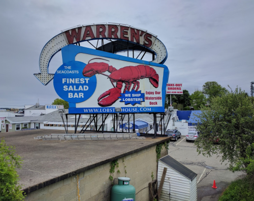 A large sign for Warren's Seafood featuring a lobster and promoting their salad bar and take-out orders.