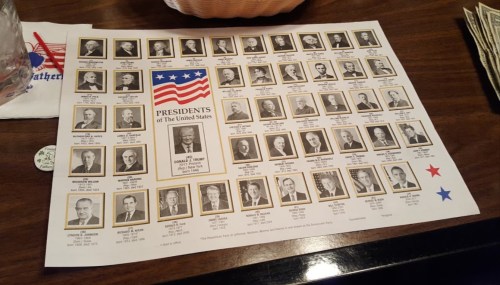A poster featuring portraits of U.S. Presidents, including Donald Trump, arranged in a grid format.