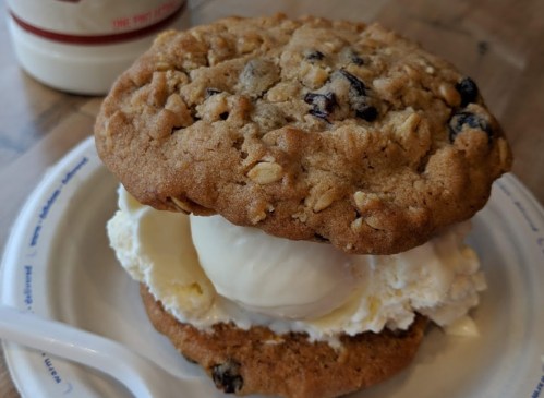 A delicious ice cream sandwich made with two oatmeal cookies and a scoop of vanilla ice cream in the middle.